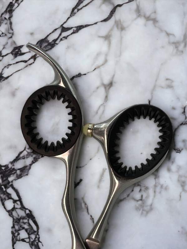 Black ShearRings inside a pair of haircutting shears on a marble background