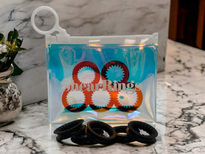 Black ShearRIngs inside iridescent packaging with a set of 5 displayed in front, on a marble background