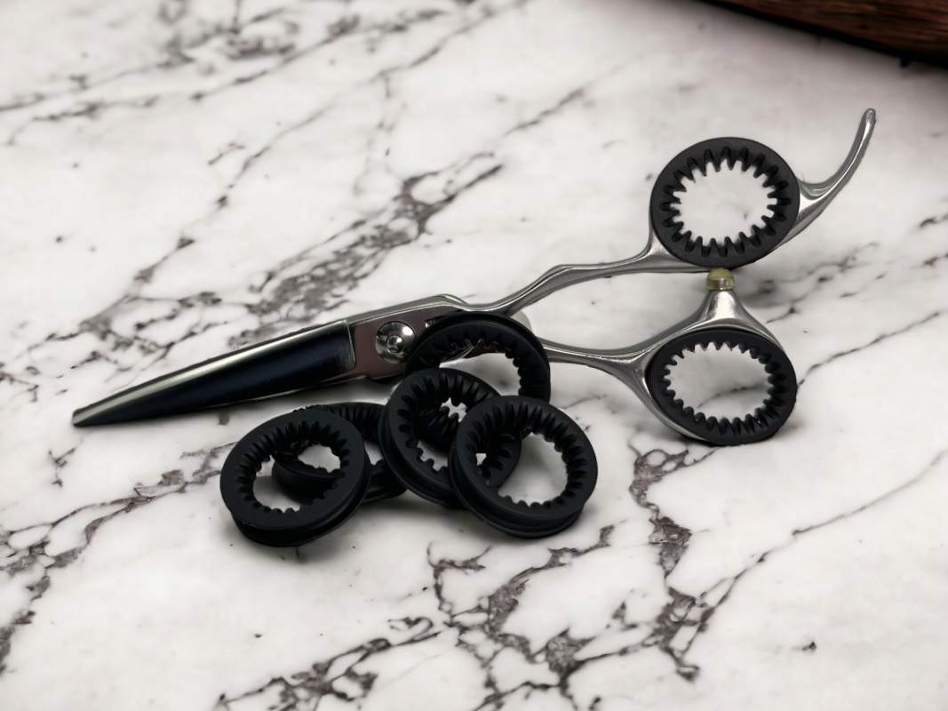 Set of 5 Black ShearRings with a set inside a pair of haircutting shears on a marble background