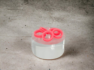 Set of 5 Coral Pink ShearRings on an acrylic cylinder with a concrete background